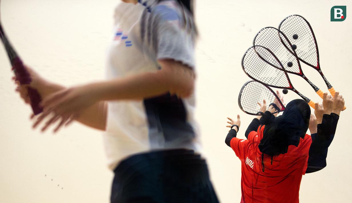 Catur Yuliana atlet squash putri Indonesia (kanan) melakukan serve saat melawan Anantana Prasertratanakul di babak penyisihan squash beregu putri Indonesia vs Thailand pada Asian Games 2018 di Stadion Squash, GBK, Kamis (30/8/2018). (Bola.com/Peksi Cahyo)