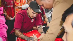 Shayne Pattynama menandatangani jersey milik Jakmania dalam acara meet & greet di Kantor Pusat Bank Jakarta pada Rabu (18/2/2025). (Bola.com/Nur Iman Ali)