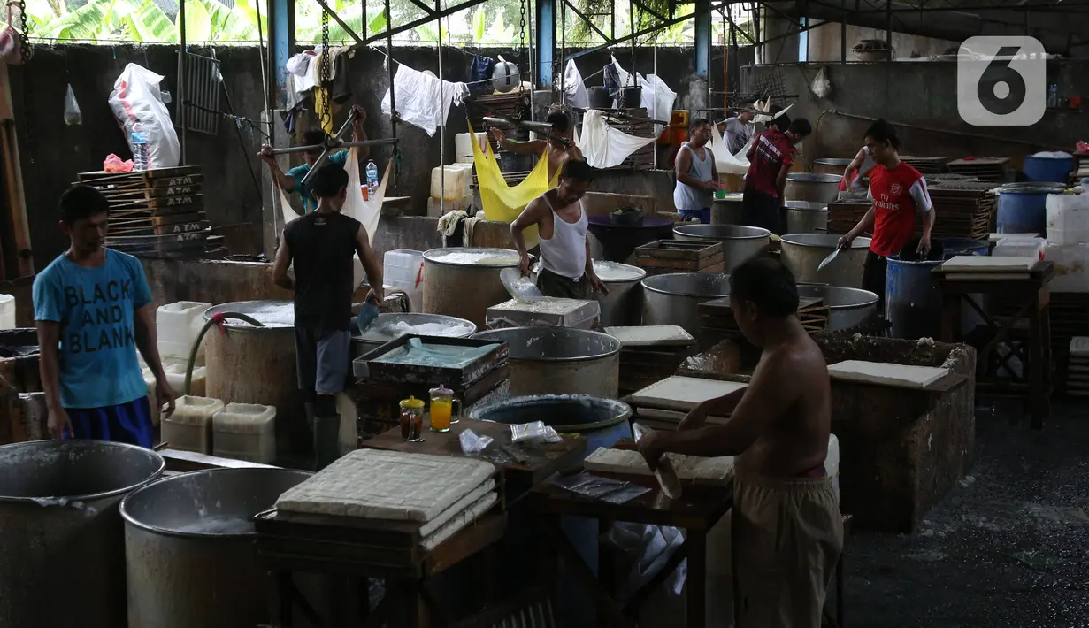 Pekerja memotong tahu yang baru dicetak di industri rumahan kawasan Jakarta, Selasa (17/12/2019). Pemerintah juga menaikkan plafon penyaluran KUR plafon secara signifikan 36% dari Rp 140 triliun menjadi Rp 190 triliun tahun 2020. (Liputan6.com/Angga Yuniar)