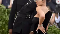 Kylie Jenner bersama sang kekasih, Traviz Scott berpose setibanya pada ajang Met Gala 2018 di Metropolitan Museum of Art New York, Senin (7/5). Travis mengenakan setelan jas hitam dengan aksen sabuk mengelilingi tubuhnya. (Evan Agostini/Invision/AP)