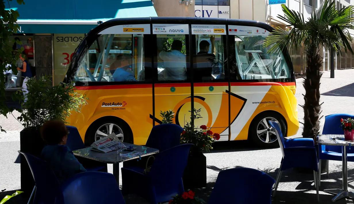 Sejumlah penumpang berada didalam angkutan umum tanpa kemudi dan sopir di Sion, Swiss, Kamis (23/6). Angkutan umum listrik pertama buatan PostAuto Schweiz ini memiliki 11 kursi penumpang dengan kecepatan maksimal 20 km per jam. (REUTERS/Ruben Sprich)