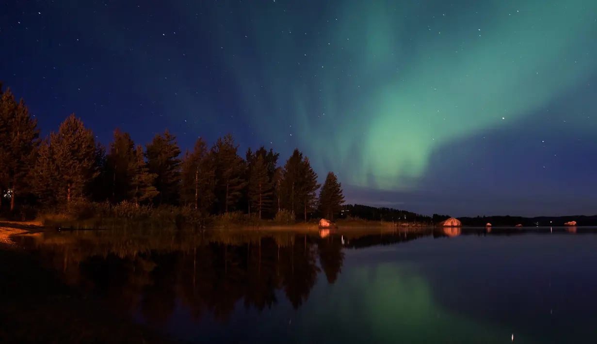 Langit desa Erikslund  berhias cahaya aurora borealis, di Swedia, (23/8). Fenomena langka ini muncul dari tabrakan antara partikel gas di atmosfer bumi dengan partikel bermuatan dari matahari. (AFP PHOTO/ JONATHAN NACKSTRAND)