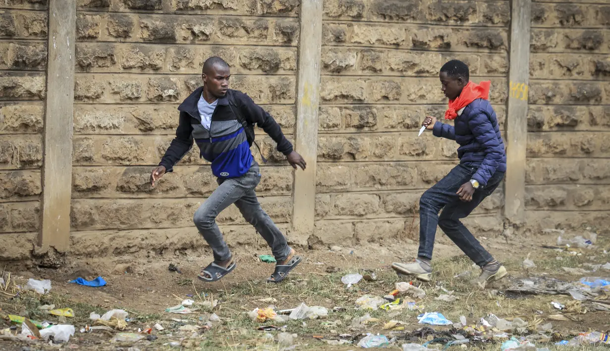 Seorang pria tak dikenal memegang pisau mencoba merampok seorang pejalan kaki saat bentrokan antara polisi dan pengunjuk rasa di lingkungan Mathare di Nairobi, Kenya Rabu, 12 Juli 2023. (AP Photo)