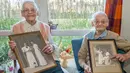 Paulette Olivier (kiri) dan Simone Thiot memperlihatkan foto semasa muda di Ephad "Les Bois Blancs", Prancis (13/2). Paulette dan Simone lahir pada 30 Januari 1912 di Limeray, beberapa kilometer dari Amboise. (AFP PHOTO/GUILLAUME souvent)