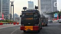 Kendaraan water canon Brimob Polda Metro Jaya menyemprotkan air di kawasan Bundaran HI, Jakarta, Rabu (23/8/2023). Pemerintah Provinsi (Pemprov) DKI Jakarta dan Polda Metro Jaya melakukan penyemprotan air di sepanjang Jalan Medan Merdeka Barat hingga Patung Pemuda Membangun Senayan sebagai upaya untuk mengurangi polusi udara dan mengatasi cuaca panas di Ibu Kota. (Liputan6.com/Angga Yuniar)