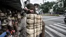 Pembeli membawa besek bambu di kawasan Jatinegara, Jakarta, Senin (19/7/2021). Pedagang mengaku harga jual besek bambu tetap stabil dengan kisaran Rp3.000 hingga Rp5.000 per buah. (merdeka.com/Iqbal S. Nugroho)