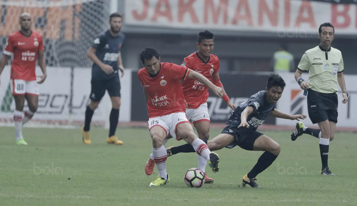Bek Persija, Michael Orah, berebut bola dengan gelandang PSM, Arfan, pada laga Liga 1 di Stadion Patriot, Bekasi, Selasa  (15/8/2017). Persija bermain imbang 2-2 dengan PSM. (Bola.com/M Iqbal Ichsan)