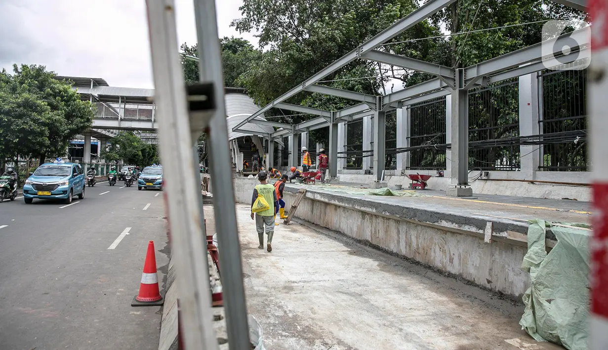 Sejumlah pekerja menyelesaikan pembangunan selter di kawasan Stasiun Palmerah, Jakarta, Selasa (2/2/2021). Penataan ini diharapkan bisa menjadi solusi kemacetan yang kerap terjadi di kawasan tersebut. (Liputan6.com/Faizal Fanani)