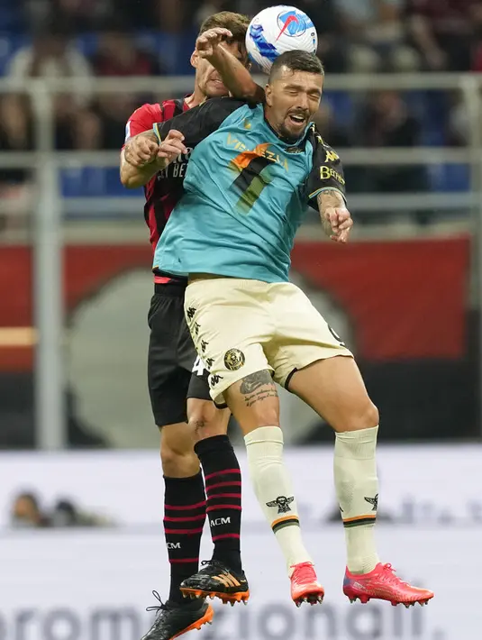 Penyerang Venezia, Francesco Forte dan bek AC Milan, Matteo Gabbia melompat saat berebut bola pada laga pekan ke-5 Serie A 2021/22 di San Siro, Kamis (23/9/2021) dini hari WIB. AC Milan Milan menaklukkan tamunya Venezia 2-0. (AP Photo/Antonio Calanni)