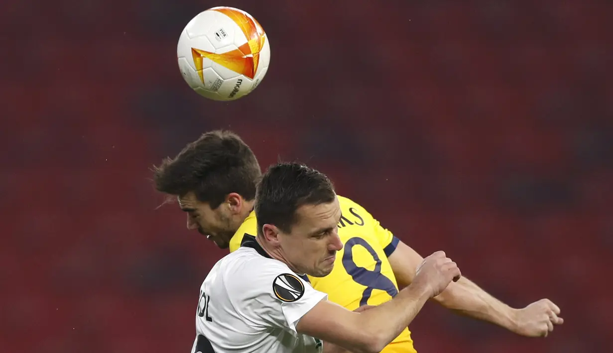 Gelandang Tottenham, Harry Winks berebut bola udara dengan pemain Wolfsberger AC, Michael Liendl pada leg pertama babak 32 besar Liga Europa di stadion Puskas Arena di Budapest, Hongaria, Jumat (19/2/2021). Tottenham menang telak atas Wolfsberger 4-1. (AP Photo/Laszlo Balogh)