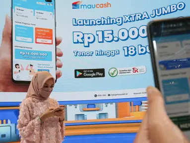 Pengunjung mencoba aplikasi Maucash di sela-sela peluncuran Mauringan XTRA Jumbo pada Event GIIAS Jakarta 2021, Jumat (19/11/2021). Perusahaan Fintech Lending yang terhubung ke ekosistem Grup Astra menargetkan penyaluran pinjaman Maucash mencapai Rp 2 triliun hingga akhir tahun. (Liputan6.com)