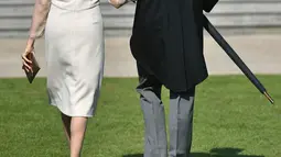 Duke dan Duchess of Sussex, Pangeran Harry dan Meghan Markle menghadiri pesta kebun Istana Buckingham di London, Selasa (22/5). Penampilan Meghan ini sekaligus merayakan ulang tahun ke-70 ayah mertuanya, Pangeran Charles. (Dominic Lipinski/Pool via AP)