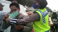 Seorang Polwan memakaikan masker kepada pengendara motor di jalanan Kota Batam, Kepulauan Riau, yang mulai diselimuti kabut asap. (Liputan6.com/Ajang Nurdin) 