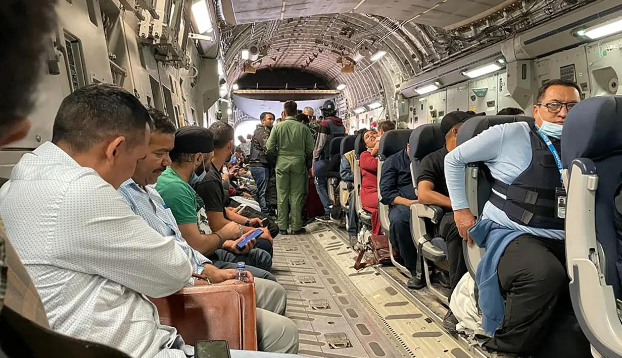 Warga negara India duduk di atas pesawat militer India untuk dievakuasi setelah pengambilalihan Afghanistan oleh pejuang Taliban di bandara di Kabul (17/8/2021). Sebagian kecil warga India tetap di negara tersebut dan tengah diupayakan untuk dibawa kembali oleh pihak berwenang. (AFP Photo)
