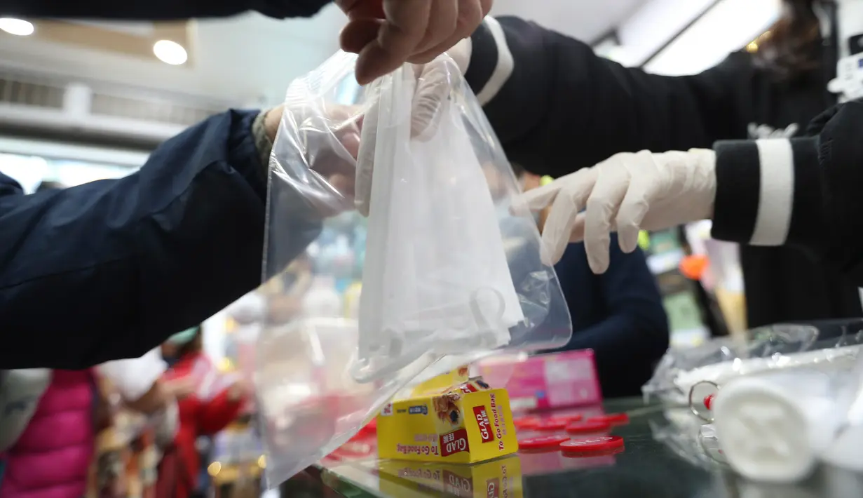 Warga menerima masker wajah gratis dalam sebuah toko di Tsuen Wan, Hong Kong, Selasa (28/1/2020). Hong Kong terkonfirmasi memiliki delapan kasus infeksi virus corona. (AP Photo/Achmad Ibrahim)
