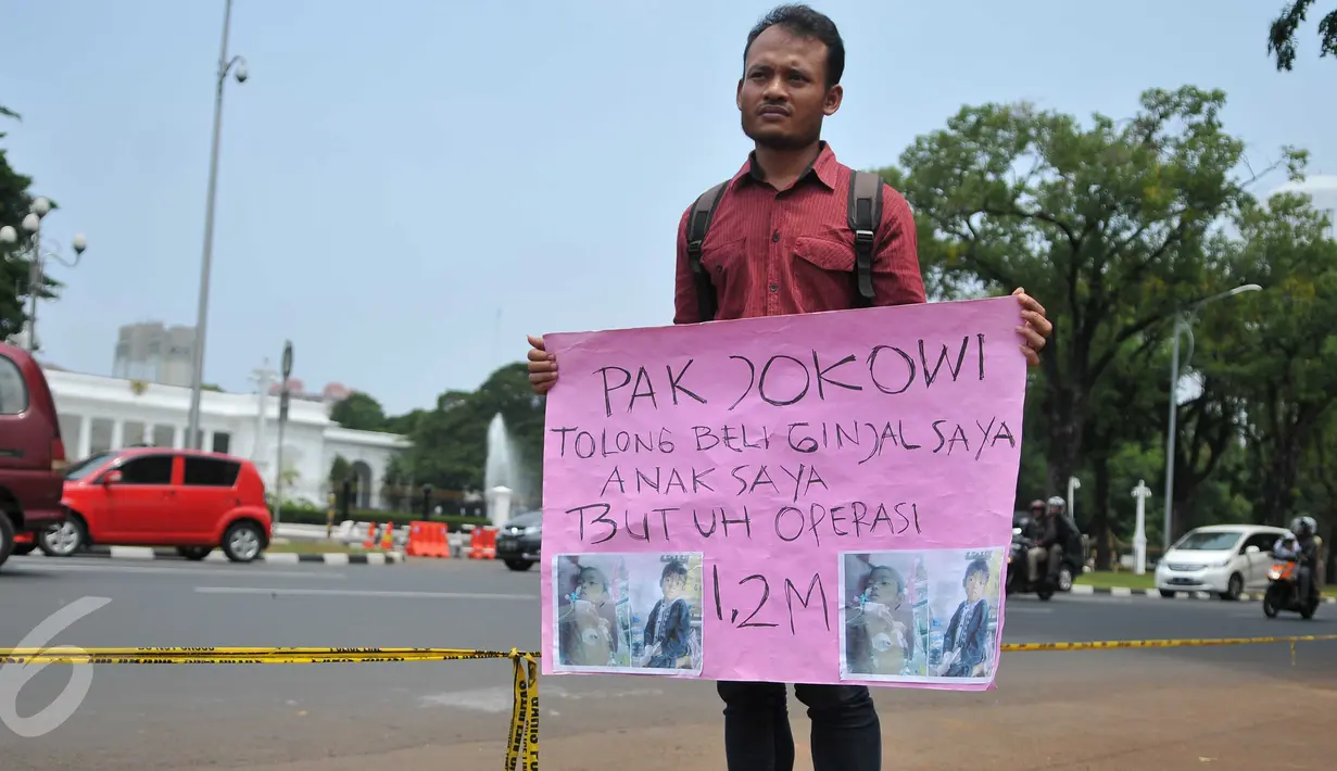 Susanto (28) melakukan aksi jual ginjal di depan Istana Merdeka, Jakarta, Jumat (20/11). Dalam aksinya, bapak muda itu meminta Presiden Jokowi membeli ginjalnya guna membiayai operasi transplantasi hati sang anak. (Liputan6.com/Gempur M Surya)