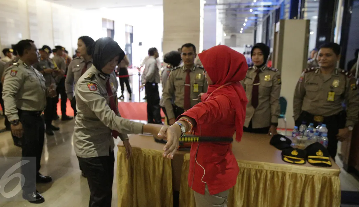 Seorang polwan memeriksa pengunjung yang hendak masuk dalam Debat terakhir Pilgub DKI Jakarta 2017, Jakarta, Rabu (12/4). Tema debat terakhir Pilgub DKI adalah 'Dari Masyarakat Jakarta untuk Jakarta'. (Liputan6.com/Faizal Fanani)