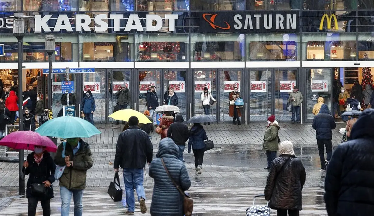 Orang-orang berjalan ke pusat perbelanjaan di pusat Kota Essen, Jerman, Senin (14/12/2020). Jerman melakukan lockdown nasional pada 16 Desember 2020 untuk memerangi pandemi COVID-19. (AP Photo/Martin Meissner)