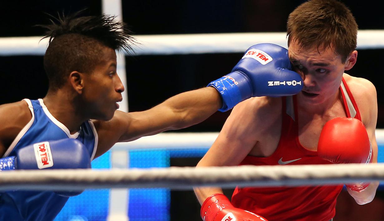 Petinju Kuba, Michael Joahnys Argilagos memukul petinju Rusia, Vasilii Egorov pada laga AIBA World Boxing Championship di Doha, Qatar, Rabu (14/10/2015). (AFP Photo/Faisal Al-Tamimi)