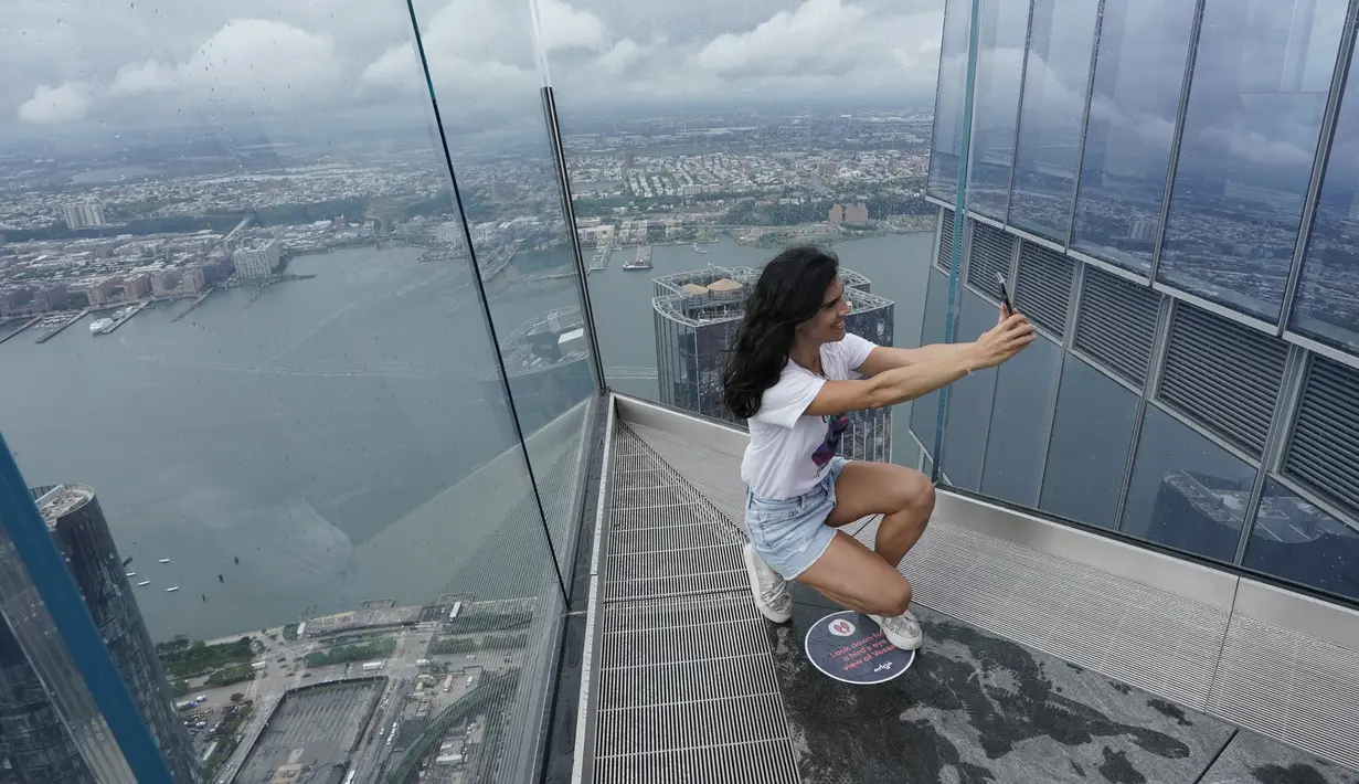 Pengunjung berswafoto dari Edge, dek langit tertinggi di luar ruangan di Western Hemisphere saat dibuka kembali untuk umum di New York, Rabu (2/9/2020). Dek pengamatan tertinggi di belahan bumi bagian barat itu menawarkan pemandangan 360 derajat langit ikonik kota New York (TIMOTHY A. CLARY/AFP)