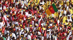 Suporter Kamerun bersorak saat upacara pembukaan turnamen sepak bola Piala Afrika (CAN) 2021 di Stade d'Olembé di Yaounde (9/1/2022). Laga pembuka Piala Afrika 2021 dimulai dengan pertandingan Kamerun vs Burkina Faso.  (AFP/Kenzo Tribouillard)