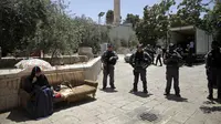 Petugas Israel melakukan penjagaan terhadap wanita muslim yang duduk di luar komplek Masjid Al- Aqsa, Yerusalem, Minggu (16/7). Setelah pekan lalu terjadi kerusuhan antara warga Arab-Israel dengan petugas kepolisian Israel. (AP/Mahmoud Illean)