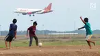 Anak-anak bermain bola di kawasan proyek perluasan landasan pacu atau Runway 3A Bandara Soekarno-Hatta (Soetta), Rawa Bokor, Tangerang, Banten, Selasa (2/7/2019). Mereka memanfaatkan lahan kosong yang belum dikerjakan pihak kontraktor untuk bermain bola. (merdeka.com/Arie Basuki)