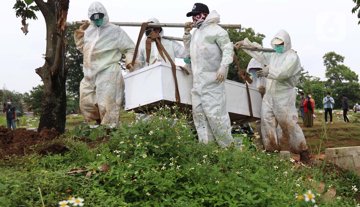 Petugas membawa peti berisi jenazah dengan protokol COVID-19 di TPU Srengseng Sawah, Jakarta, Kamis (21/1/2021). Sebagian lahan TPU Srengseng Sawah yang dijadikan lokasi pemakaman jenazah Covid-19 sejak Selasa (12/1) lalu, kini hanya tersisa 79 petak makam. (Liputan6.com/Helmi Fithriansyah)