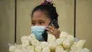Seorang pedagang menggunakan smartphone-nya saat menunggu pelanggan di kota Quezon, Senin (17/1/2022). Pemerintah Filipina melarang orang yang belum menerima vaksin COVID-19 untuk naik transportasi umum di ibu kota Manila menyusul lonjakan kasus covid varian omicron. (AP Photo/Aaron Favila)