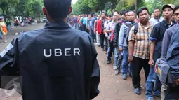 Seorang warga memakai jaket Uber usai melakukan pendaftaran menjadi pengemudi Uber di Jakarta, Selasa (24/5). Uber Indonesia membuka lowongan menjadi driver Uber Motor dengan target 10.000 pengemudi. (Liputan6.com/Angga Yuniar)