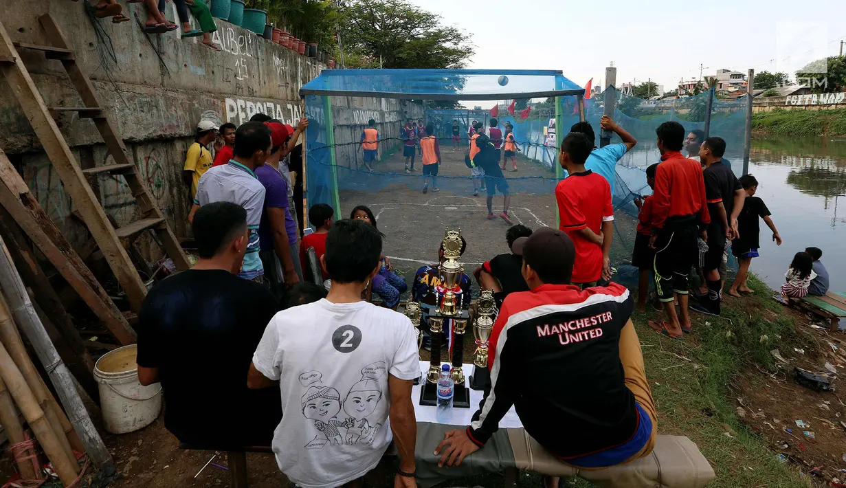 Warga bermain dalam kompetisi sepak bola di pinggir Kali Banjir Kanal Barat, Jakarta, Sabtu (5/11). Minimnya sarana bermain sepak bola mengakibatkan warga terpaksa memanfaatkan lahan di pinggir kali tersebut untuk bermain. (Liputan6.com/Johan Tallo)