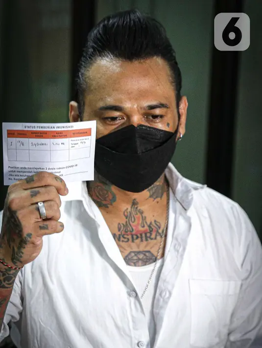 Musikus I Gede Ary Astina alias Jerinx  menunjukkan kartun vaksin covid-19 usai menerima suntikan di Biddokkes Polda Metro Jakarta, Sabtu (15/8/2021). Jerinx akhirnya memutuskan untuk menerima suntikan vaksin Sinovac dosis pertama. (Liputan6.com/Faizal Fanani)