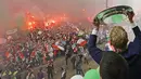Pemain dan suporter bersorak merayakan pesta juara Liga Belanda di Rotterdam (15/5). Bagi Feyenoord, ini adalah gelar liga pertama dalam kurun waktu 18 tahun terakhir atau yang ke-15 sepanjang sejarah klub. (AFP Photo/ANP/Olaf Kraak/Netherlands Out)