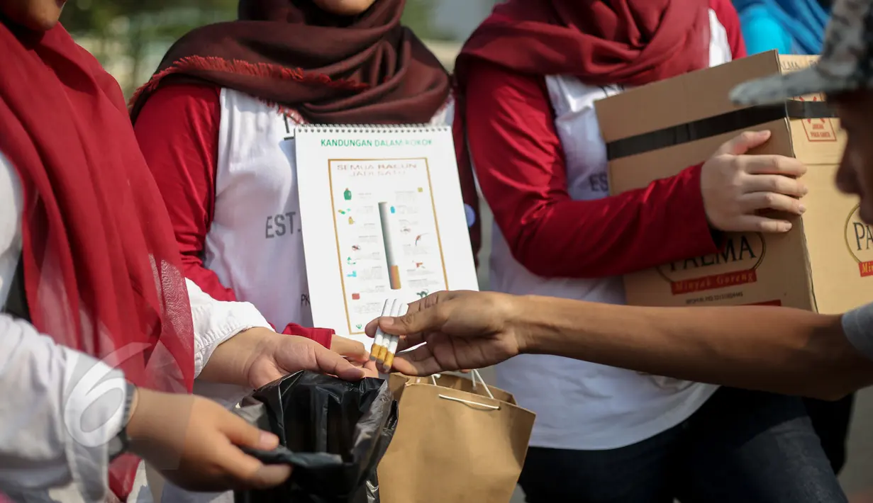 Para peserta car free day (CFD) menyerahkan rokok mereka saat peringatan Hari Tanpa Tembakau di Bundaran HI, Jakarta, Minggu (31/5/2015). (Liputan6.com/Faizal Fanani)