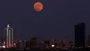 Bulan Purnama Stroberi atau Strawberry Full Moon muncul di atas Kota Kuwait, pada Kamis (24/6/2021). Strawberry Full Moon adalah istilah yang diambil dari hikayat atau cerita tradisi dari suku-suku asli Amerika. (YASSER AL-ZAYYAT / AFP)
