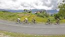 Para pebalap melintasi sawah dan Rumah Gadang pada jalur kelok 44  etape ke-4 Tour de Singkarak 2016 di Kabupaten Agam, Sumatera Barart. (Bola.com/NIcklas anoatubun)