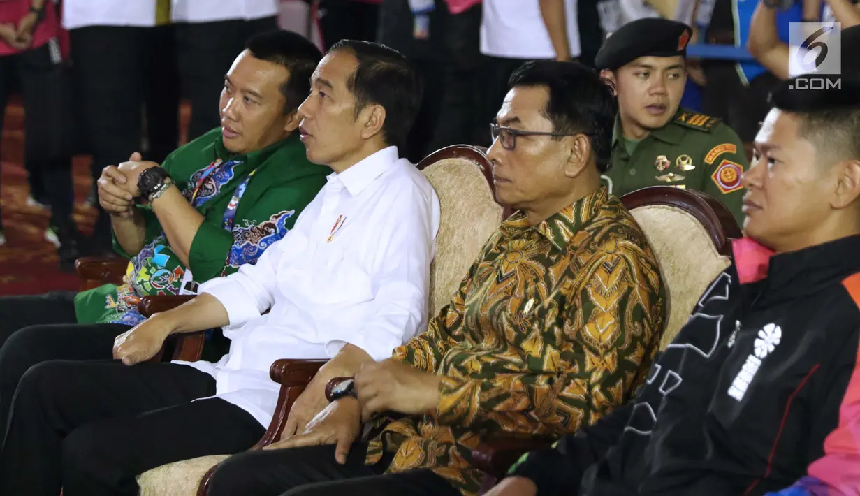Presiden RI, Joko Widodo (kedua kiri) berbincang bersama Menpora Imam Nahrawi jelang menyaksikan laga atlet para powerlifting Indonesia di kelas Womens Up 73 dan 79kg Asian Para Games 2018 di Jakarta, Rabu (10/10). (Liputan6.com/Helmi Fithriansyah)
