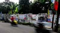 Jejeran spanduk yang memasang foto para caleg juga menghiasi tembok di sekitar kawasan Pejaten, Jakarta Selatan, Kamis (13/3) (Liputan6.com/Andrian M Tunay)