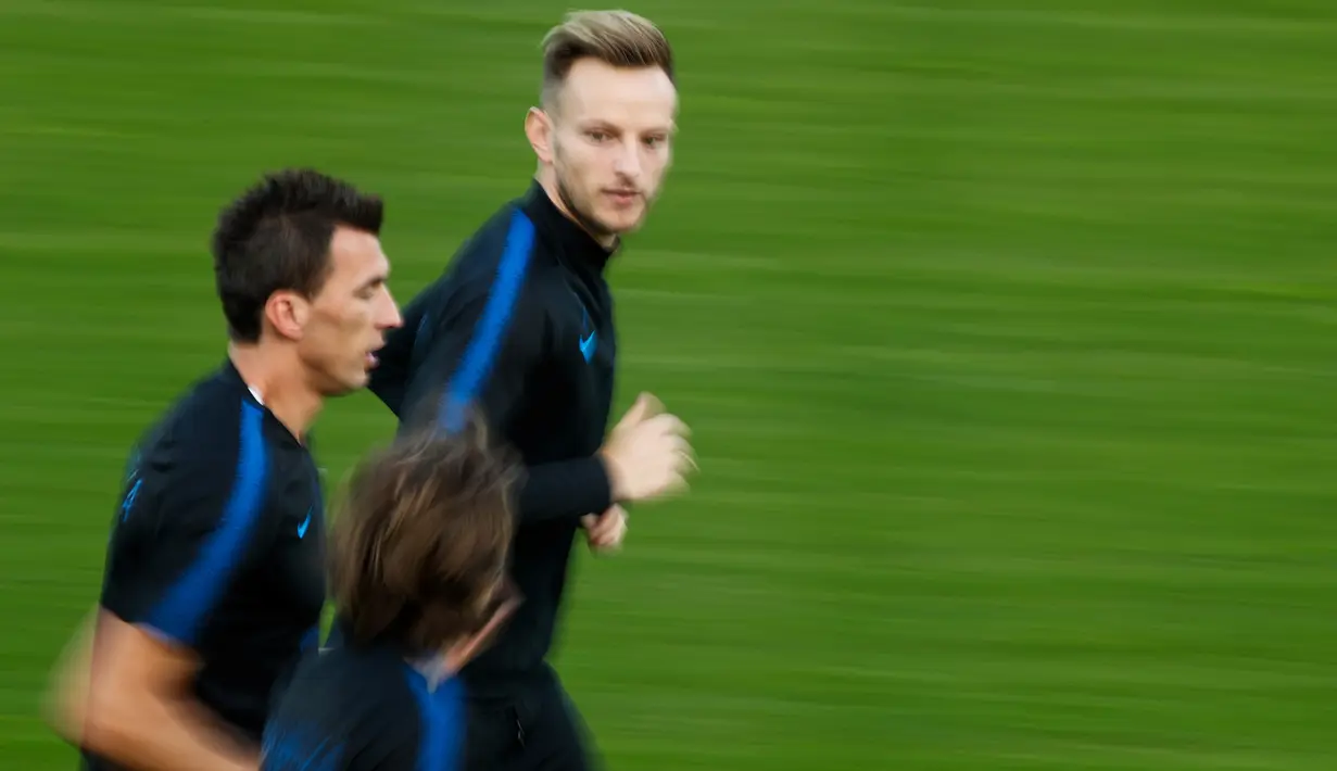 Pemain Kroasia, Mario Mandzukic, Luka Modric dan Ivan Rakitic melakukan pemanasan selama mengikuti sesi pelatihan tim jelang menghadapi Prancis pada babak Final Piala Dunia 2018 di Moskow, Rusia, (13/7). (AFP Photo/Odd Andersen)