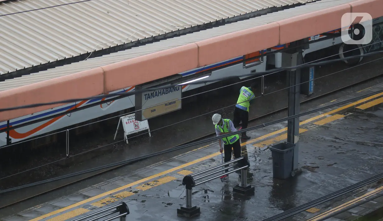 Petugas menyapu air yang menggenangi di peron Stasiun kereta Tanah Abang, Jakarta, Rabu (1/1/2020). Hujan yang mengguyur Jakarta sejak Selasa sore (31/12/2019) mengakibatkan rel terendam dan perjalanan kereta dari dan ke Stasiun Tanah Abang dihentikan. (Liputan6.com/Helmi Fithriansyah)