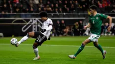 Gelandang Timnas Jerman, Serge Gnabry mengontrol bola dengan dibayangi pemain Irlandia Utara pada laga Grup C Kualifikasi Piala Eropa 2020 di Commerzbank Arena, Selasa (19/11/2019). Timnas Jerman benamkan Irlandia Utara dengan skor telak 6-1 berkat bantuan hat-trick dari Gnabry. (AP/Michael Probst)
