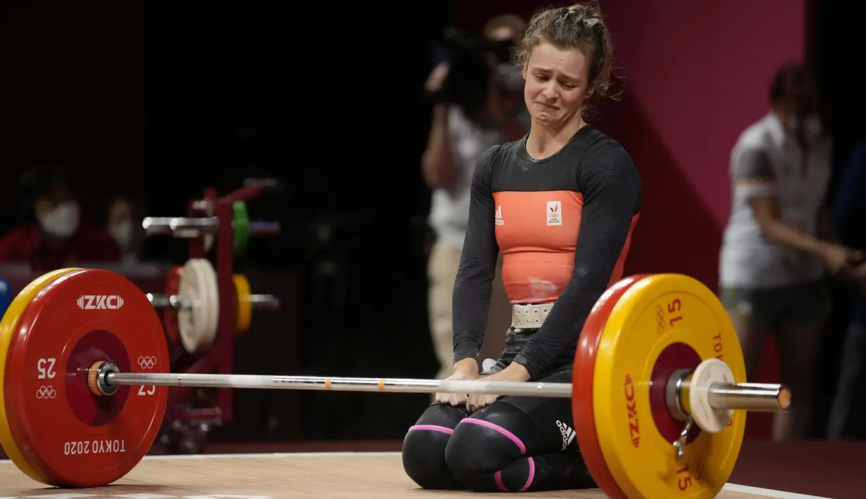 Lifter Belgia Nina Sterckx menangis setelah usahanya gagal saat bertanding dalam cabang angkat besi 49kg putri Olimpiade Tokyo 2020, pada 24 Juli 2021, di Tokyo, Jepang. (AP Photo /Luca Bruno)