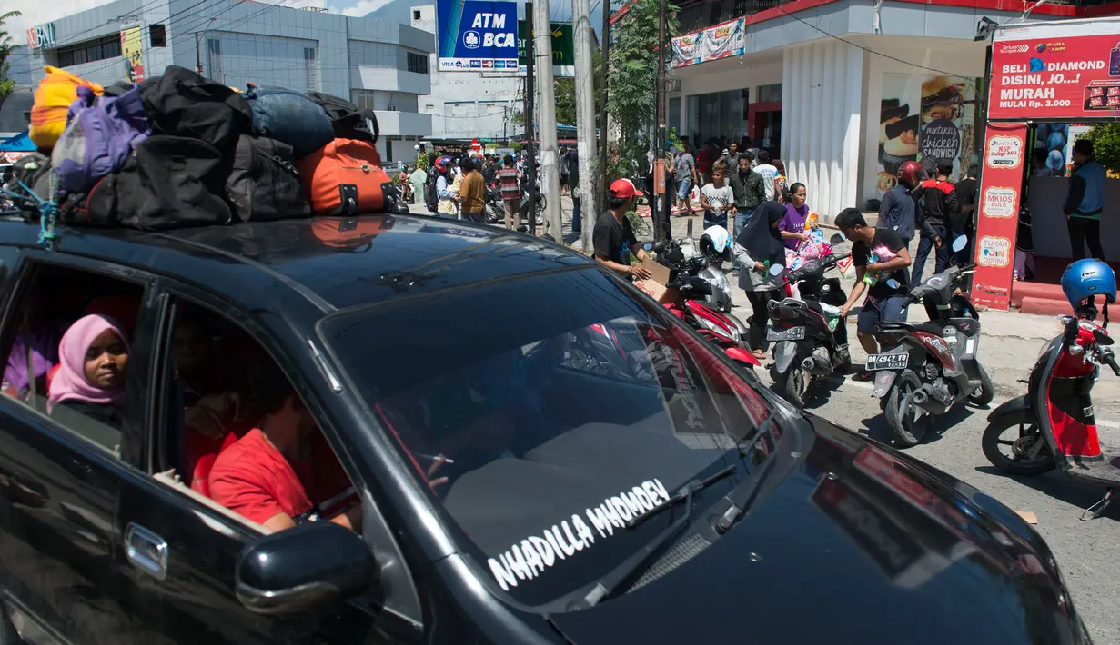 Warga menjarah kebutuhan pokok dari toko swalayan setelah gempa kuat dan tsunami mengguncang Kota Palu di Sulawesi Tengah, Minggu (30/9). Warga terpaksa mengambil karena mereka juga membutuhkan makanan dan air bersih. (AFP PHOTO/BAY ISMOYO)