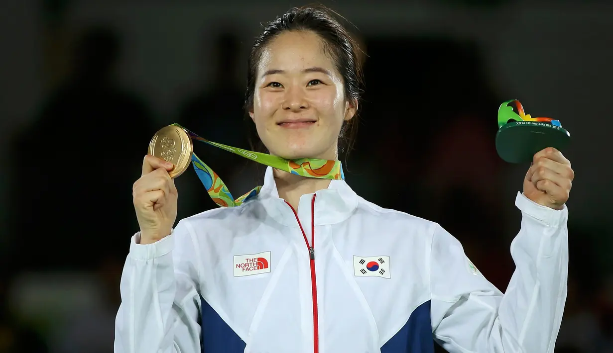 Senyum bahagia Oh Hye-Ri saat menunjukan medali emas yang ia raih di cabang Taekwondo 67kg wanita Olimpiade 2016 di Carioca Arena 3, Rio de Janeiro, Brazil, (19/8). (REUTERS/Issei Kato)