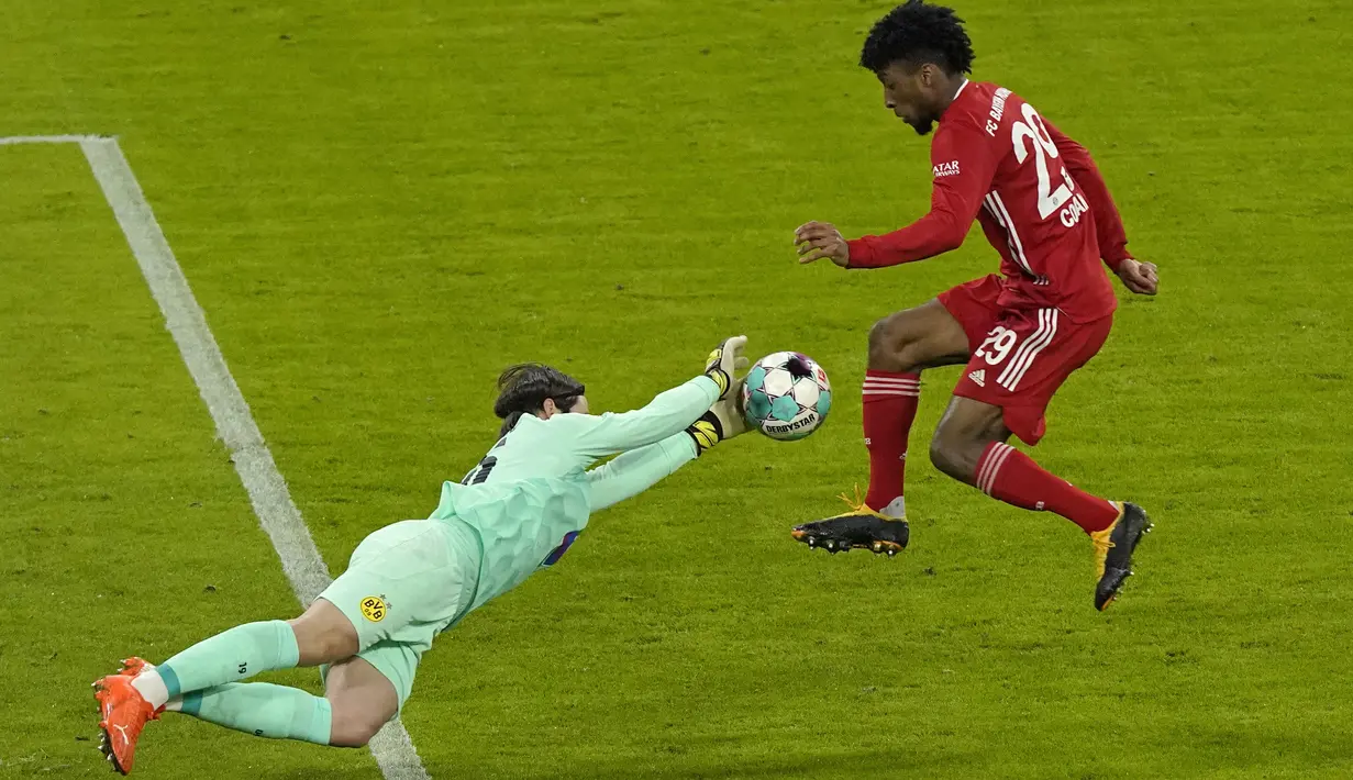 Kiper Borrusia Dortmund, Marwin Hitz menyelamatkan bola dari tendangan gelandang Bayern Munchen. Kingsley Coman pada pertandingan Bundesliga Jerman di Allianz Arena di Munich, Minggu (7/3/2021). Sementara Dortmund tertahan di peringkat enam klasemen. (Guenter Schiffmann/Pool via AP)