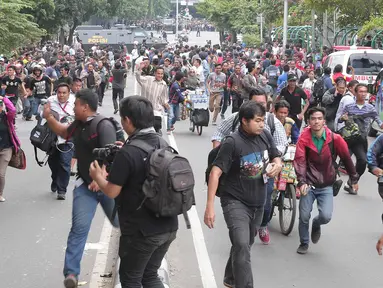 Para jurnalis lari berhamburan seusai mendengar isu bom yang akan kembali meledak pasca terjadinya ledakan yang terjadi di Pos polisi dekat pusat perbelanjaan Sarinah, Jalan Thamrin, Jakarta, Kamis (14/1). (Liputan6.com/Angga Yuniar)
