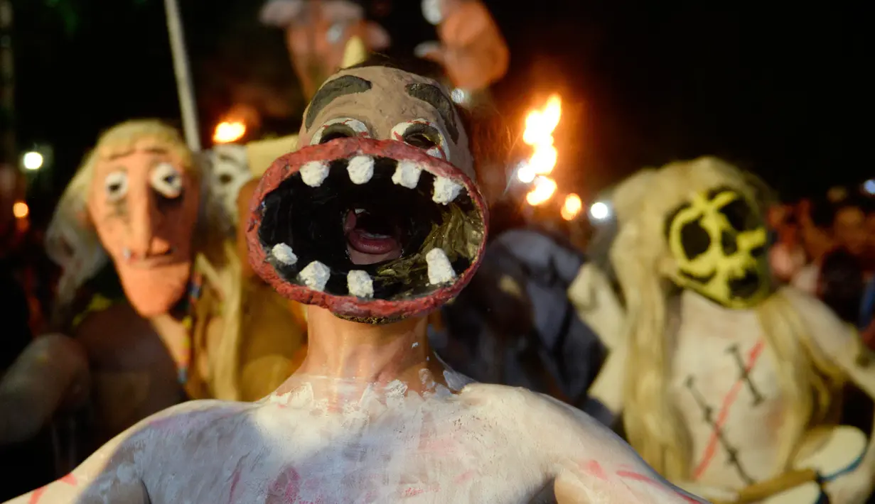 Peserta dengan memakai topeng bersuka ria mengikuti parade " La Calabiuza " di El Savador, Minggu (1/11/2015). Acara ini dirayakan oleh warga Tonacatepeque yang berada di Utara El Savador. (AFP PHOTO/Marvin RECINOS)