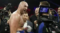 Petinju Inggris Tyson Fury merayakan kemenangan atas Tom Schwarz, dari Jerman dalam pertandingan tinju kelas berat di Las Vegas, Minggu (16/6/2019). (Foto AP / John Locher)