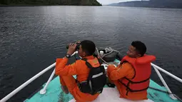Tim SAR menggunakan teropong saat proses pencarian korban KM Sinar Bangun di Danau Toba, Sumatra Utara, Rabu (20/6). Sebelumnya, KM Sinar Bangun yang mengangkut 128 penumpang tenggelam di Danau Toba pada Senin (18/6) sore. (AP/Binsar Bakkara)