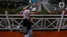 Warga melintasi Jembatan Penyeberangan Orang (JPO) di Jakarta, Kamis (31/8/2023). (Liputan6.com/Johan Tallo)